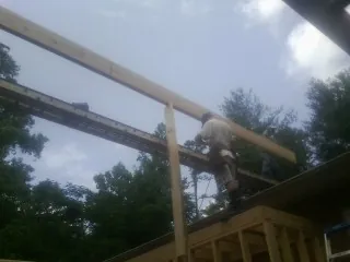 Carpenter setting a ridge beam over a new addition frame — Ice Dam Removal by Roofing Brothers in Swarthmore