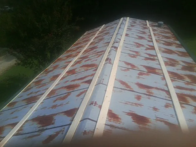 Rusted metal roof panels with new wood purlins before replacement — Storm Damage Roof Repair in Swarthmore by Roofing Brothers